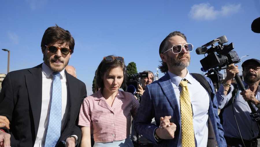 Amanda Knox arrives flanked by her husband Christopher Robinson, right, and her layer Luca Luparia Donati at the Florence courtroom in Florence, Italy, Wednesday, June 5, 2024.